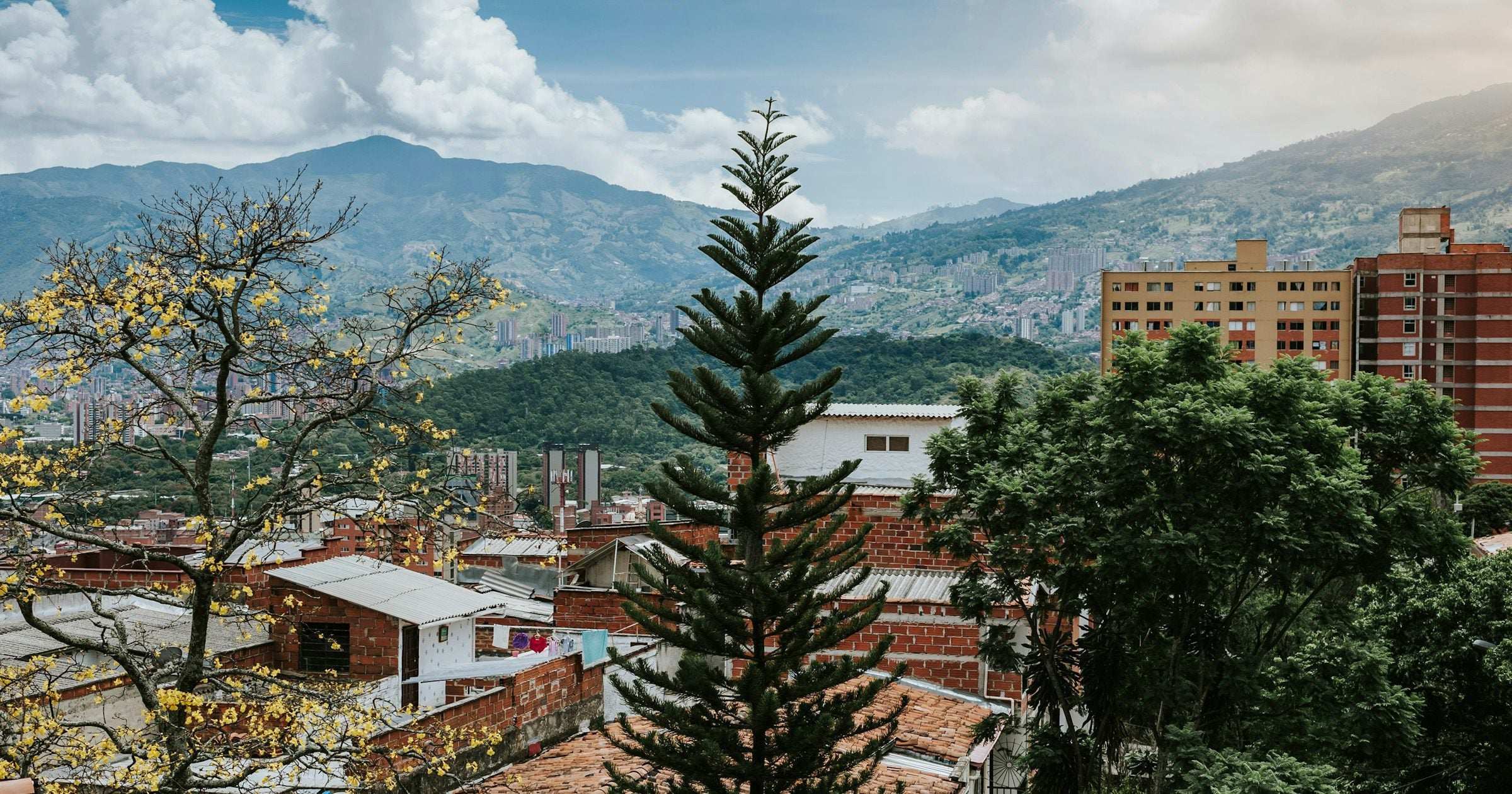 A Latin American hillside town with terracotta rooftops, mountains and trees — a typical travel destination where a visitor would activate their eSIM
