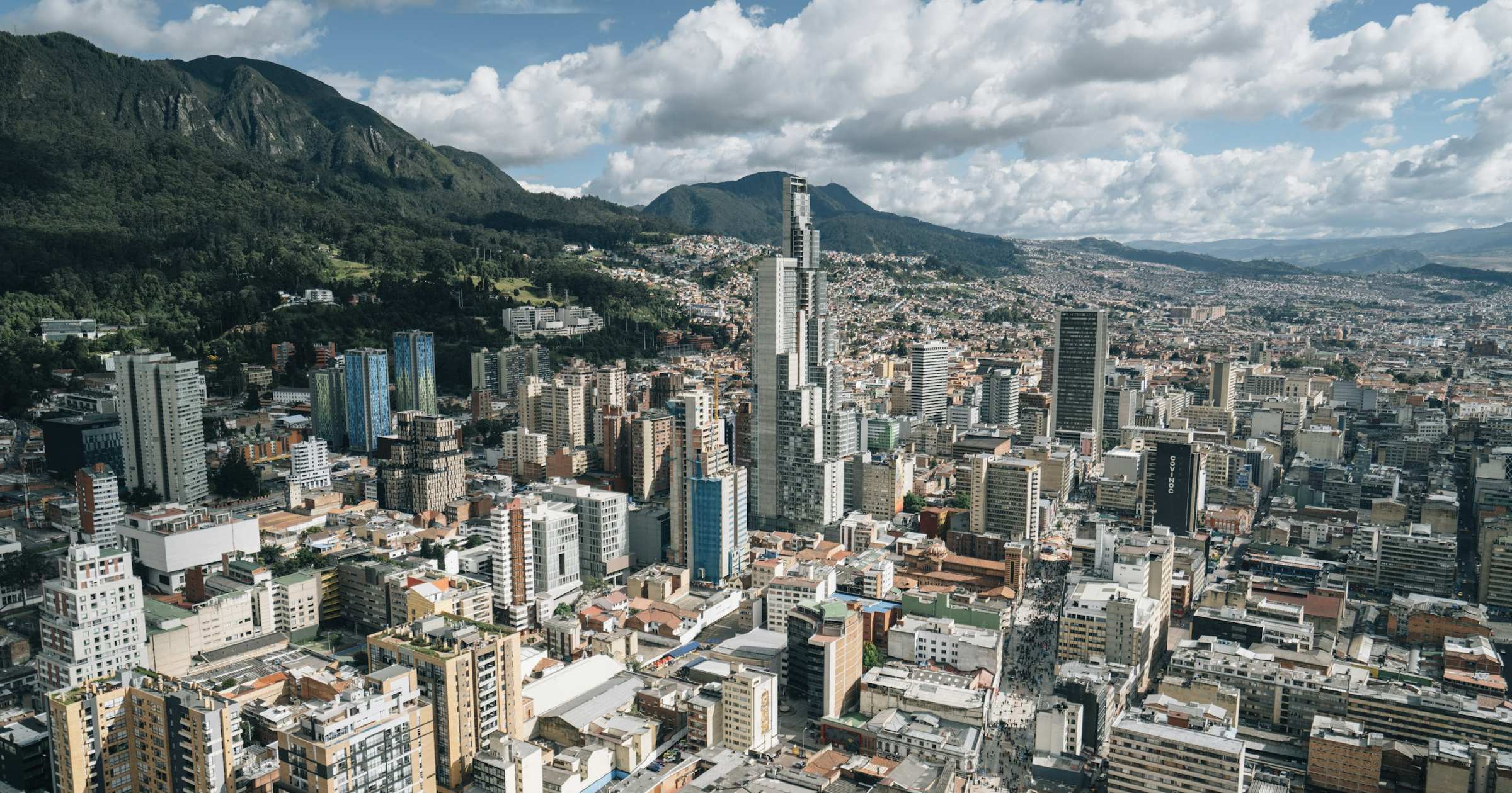 Aerial view of a Latin American city skyline with mountains in the background