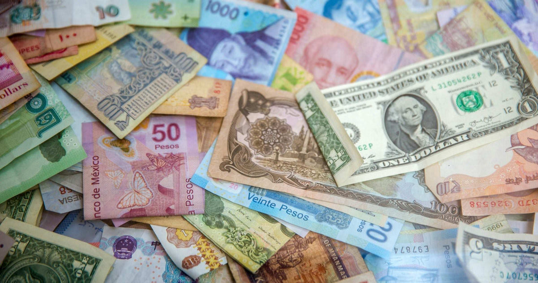 Mexican peso, Argentine peso and US dollar banknotes mixed together — visual primer for ATM and cash mechanics across Latin America.