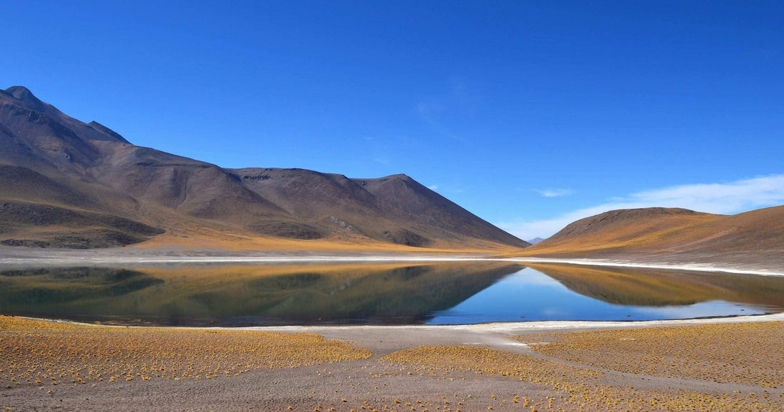Calm reflection of mountains in a high-altitude Atacama lagoon — a guide to eSIM coverage spanning a combined Europe and Latin America trip in 2026.