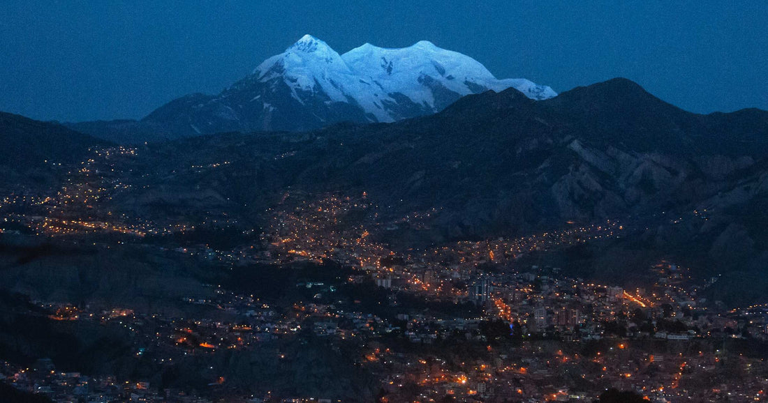 La Paz at twilight beneath snow-capped Illimani peak in the Bolivian Andes — the high-altitude landscape where travellers compare single-country versus regional eSIM coverage across Peru and Bolivia.