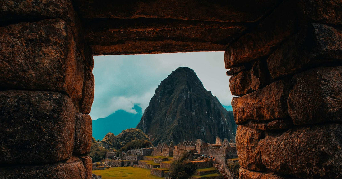 Machu Picchu citadel and Huayna Picchu framed through an ancient Incan stone archway — the iconic destination travellers visit on a Peru eSIM-connected trip.