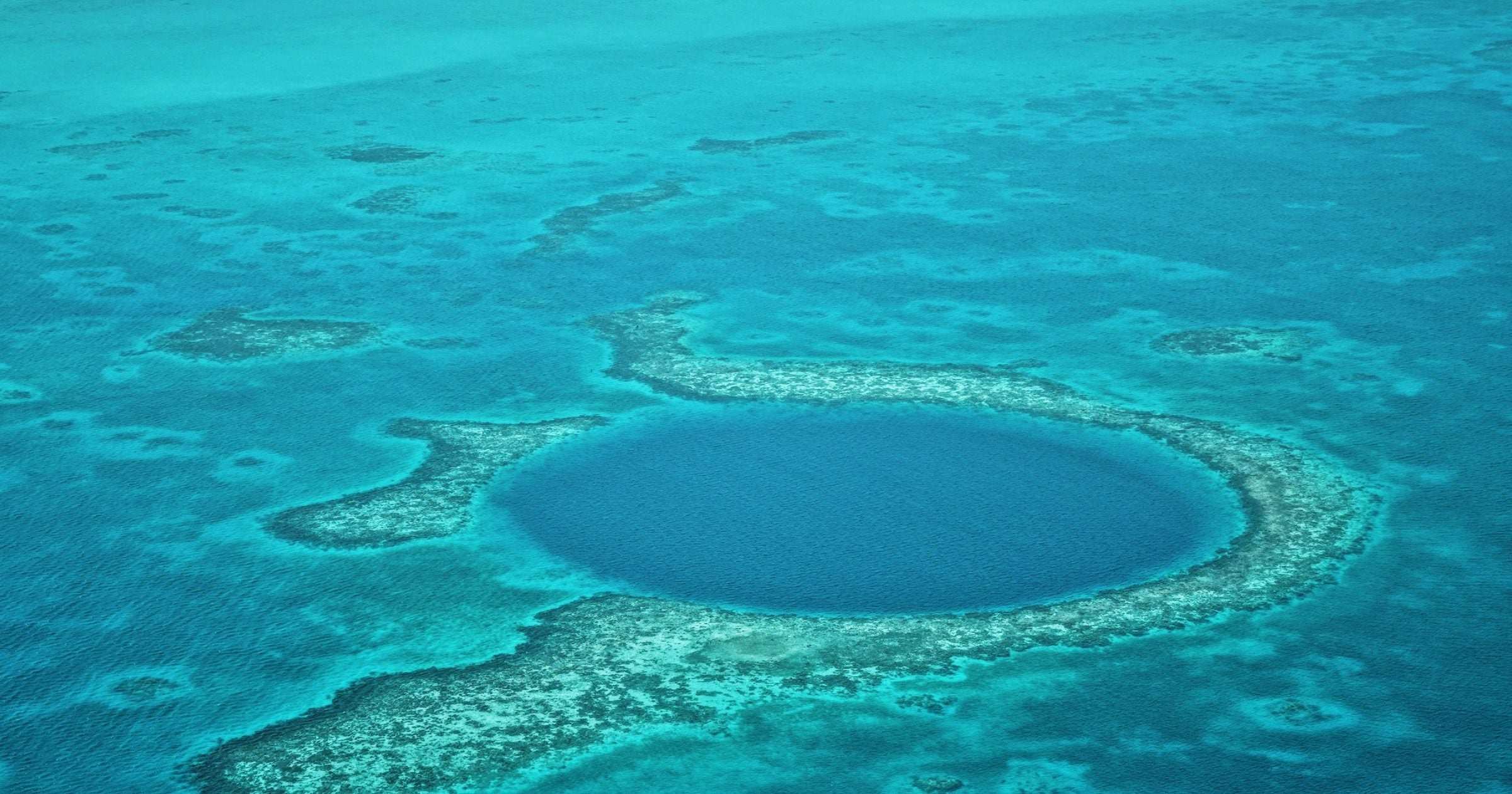 Aerial view of the Great Blue Hole in Belize barrier reef with turquoise water