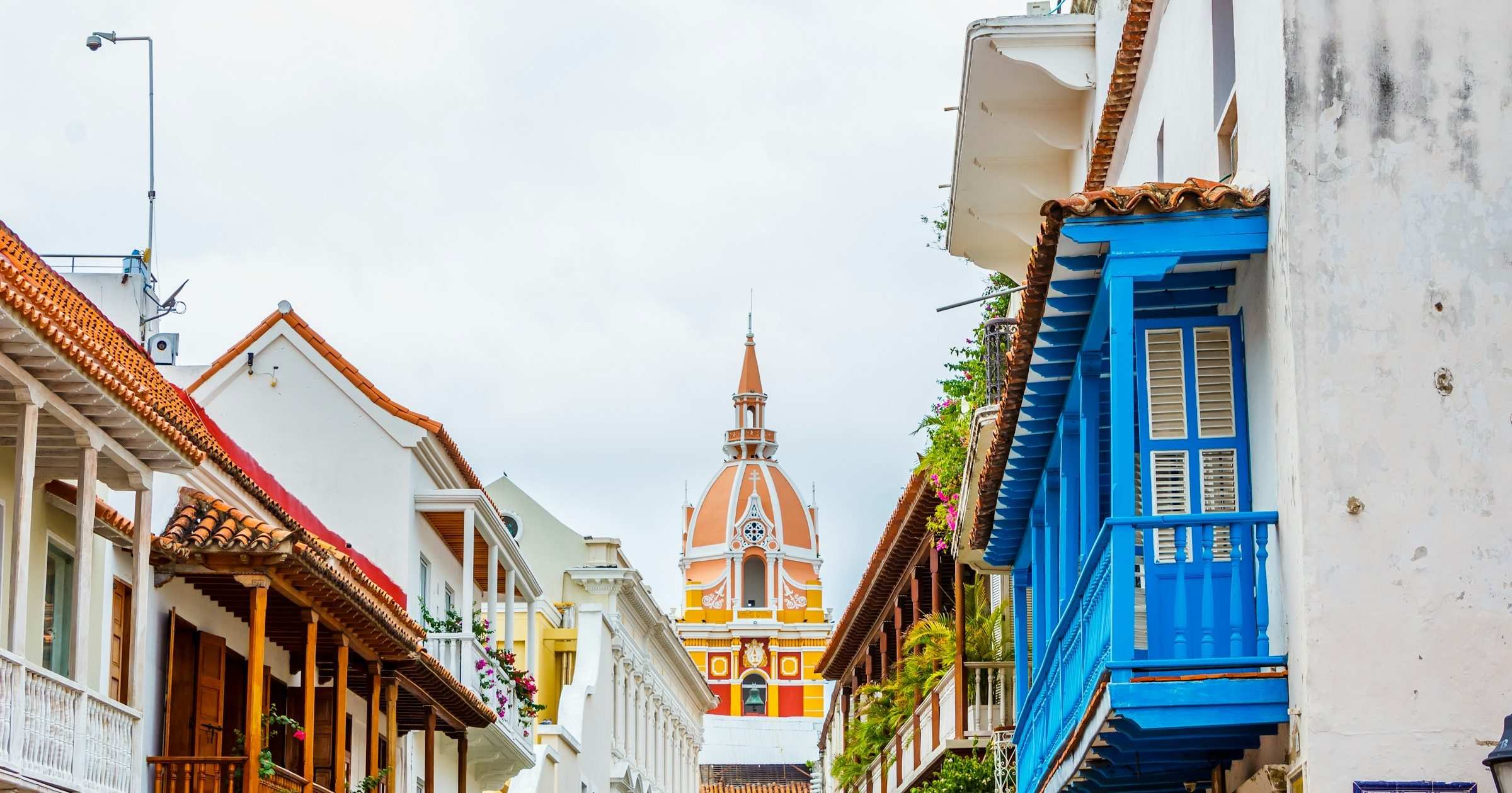 Cartagena cathedral steeple framed by colourful colonial balconies in Old Town — popular destination for travellers staying connected with a Colombia eSIM.