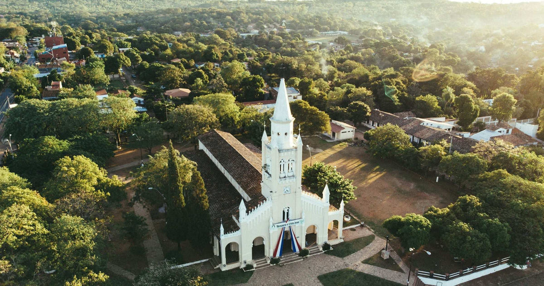 Aerial view of white colonial church in Paraguayan town surrounded by trees