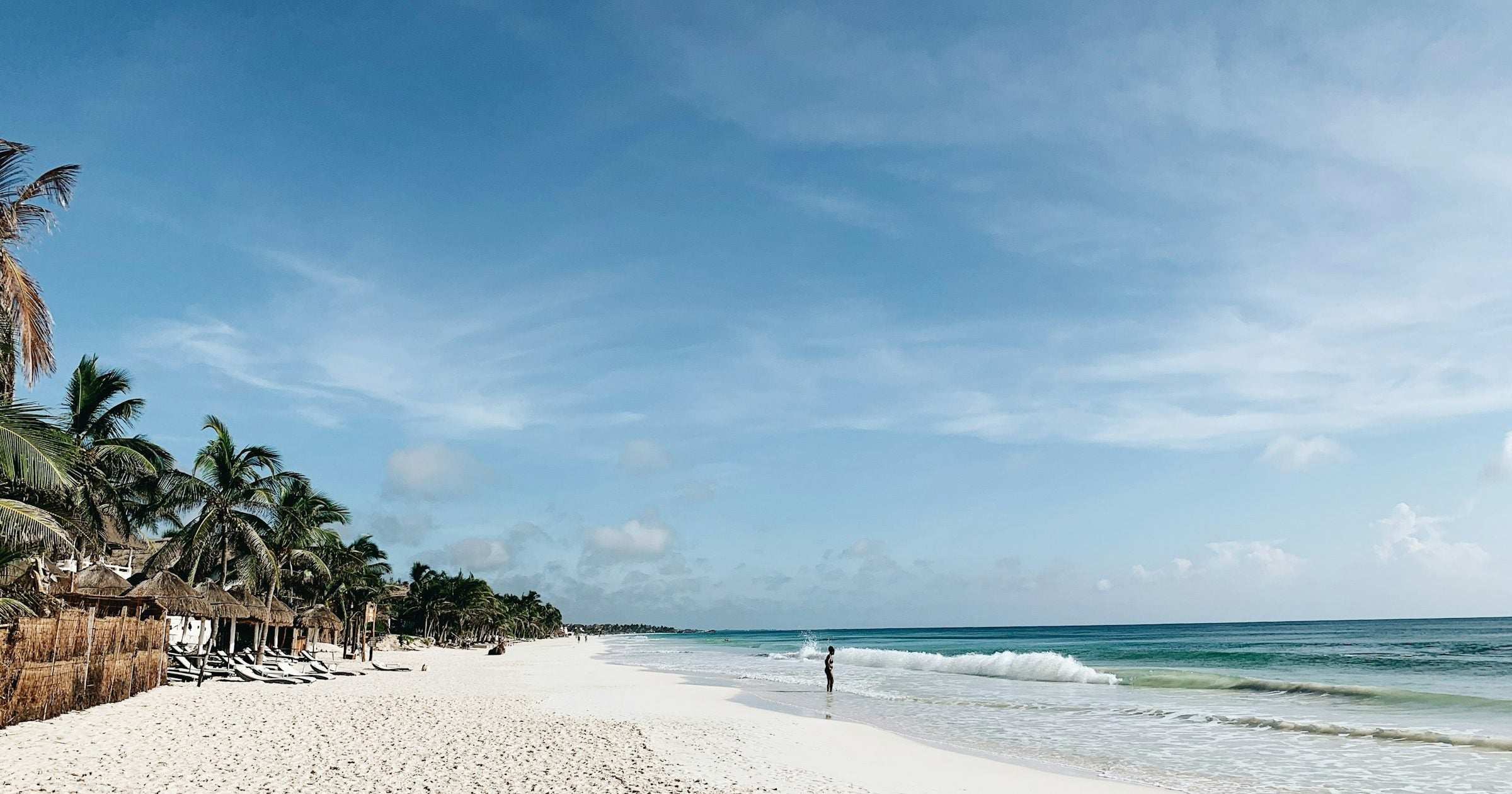 White sand beach with palm trees on the Mexican Caribbean coast — a popular destination for travellers planning a 2026 Mexico trip on any budget.