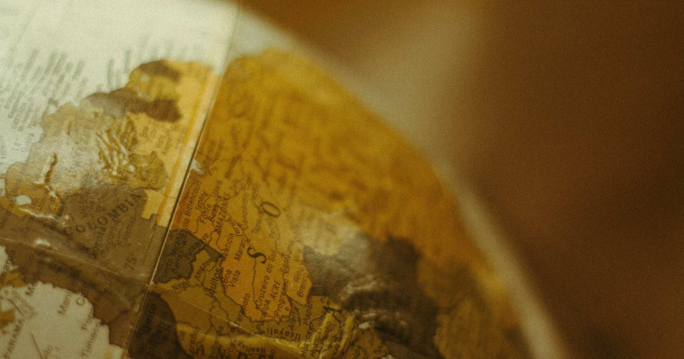 Close-up of an antique globe showing South America and the Andes — choosing the right eSIM data plan for your Latin America trip.