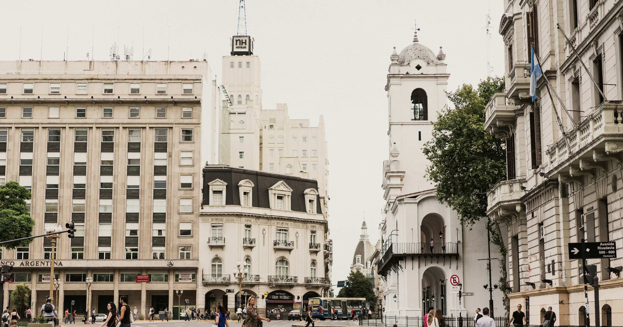 Pedestrians crossing a Buenos Aires street with colonial architecture in the background, Argentina