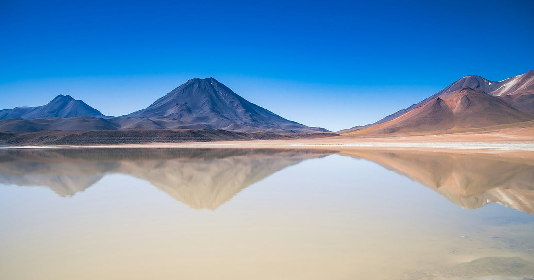 Volcanic peaks mirrored in a still high-altitude lake in the Andes, Latin America