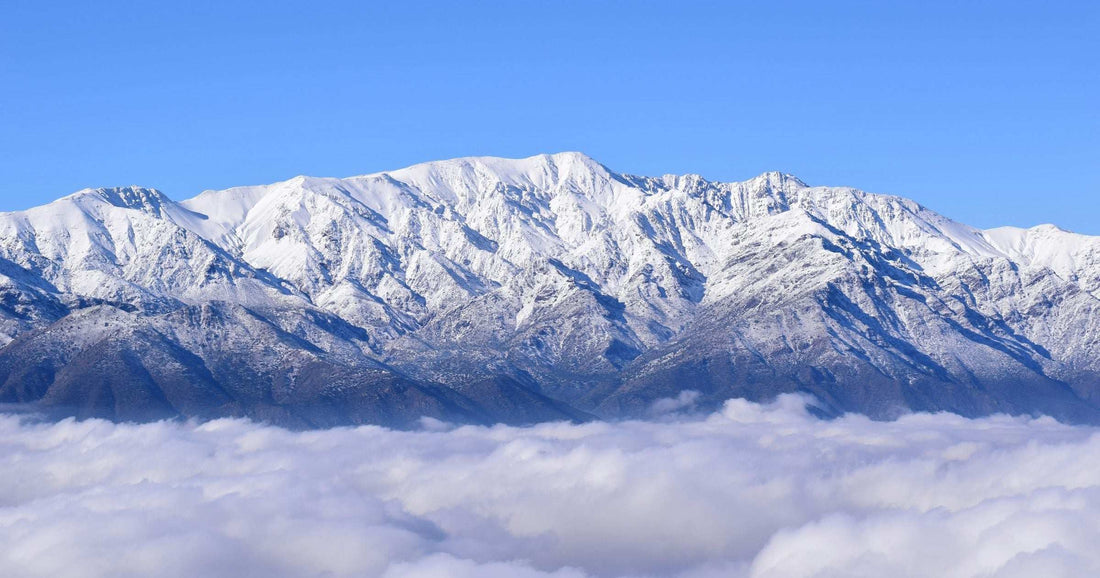 Snow-capped Andes peaks rising above clouds — planning your Latin America trip across destinations