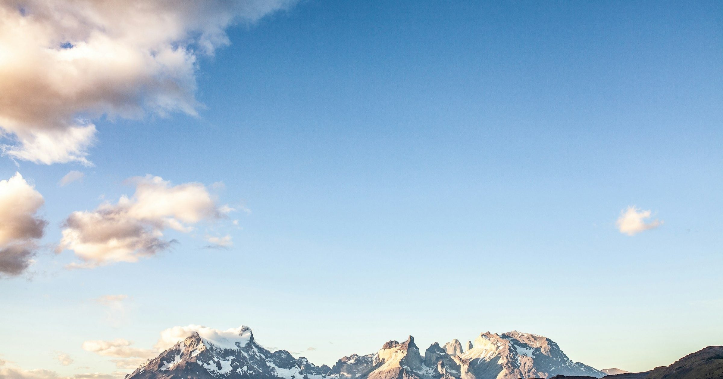 Torres del Paine towers and snow-capped Patagonia peaks at golden hour across the steppe, Argentina and Chile
