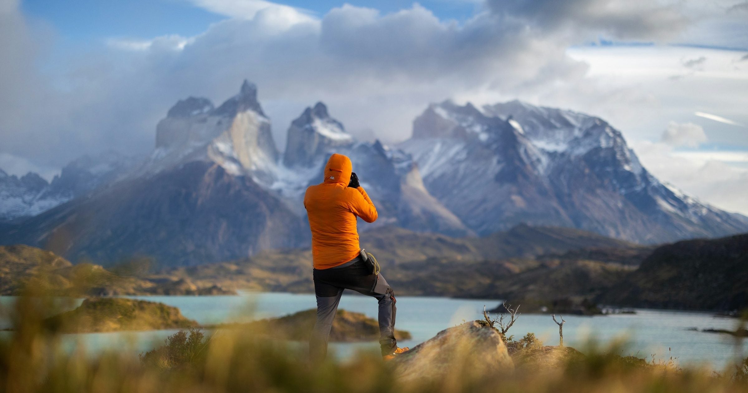 Solo traveller photographing Torres del Paine peaks and lake in Patagonia, South America
