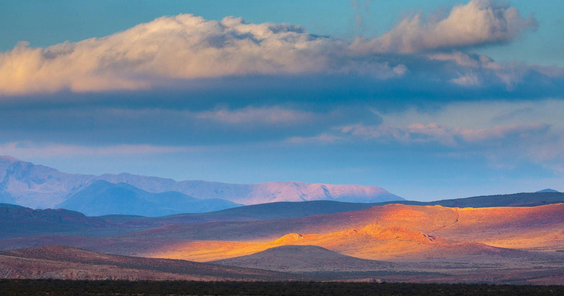 Dramatic sunset light over orange hills and gathering clouds in the South American highlands — weather varies by country across May 2026.