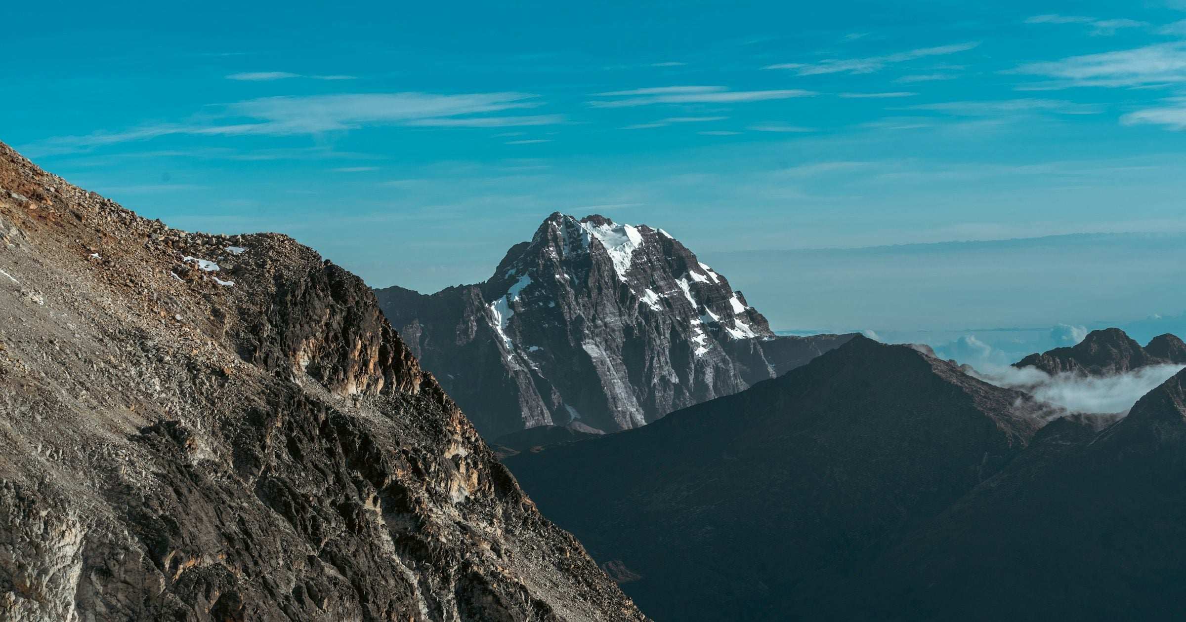 Snow-capped Andean peak rising under a deep blue Latin American sky
