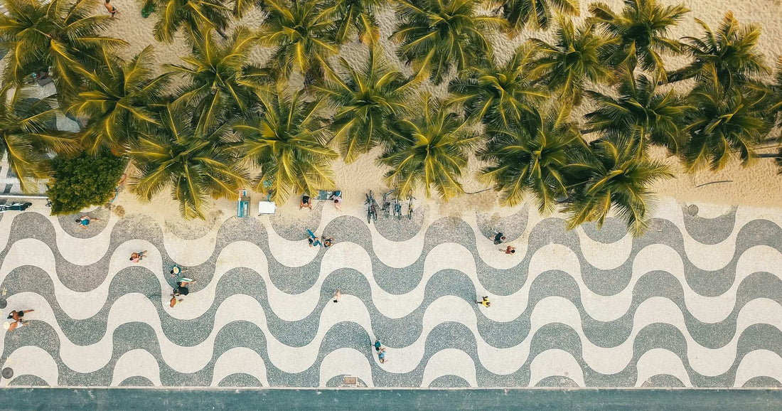 Aerial view of Copacabana beach waveform pavement and palm trees in Rio de Janeiro — an iconic urban Brazilian scene for travellers comparing local WiFi and internet costs.